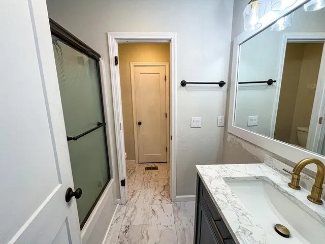 a bathroom with a granite countertop sink and a mirror