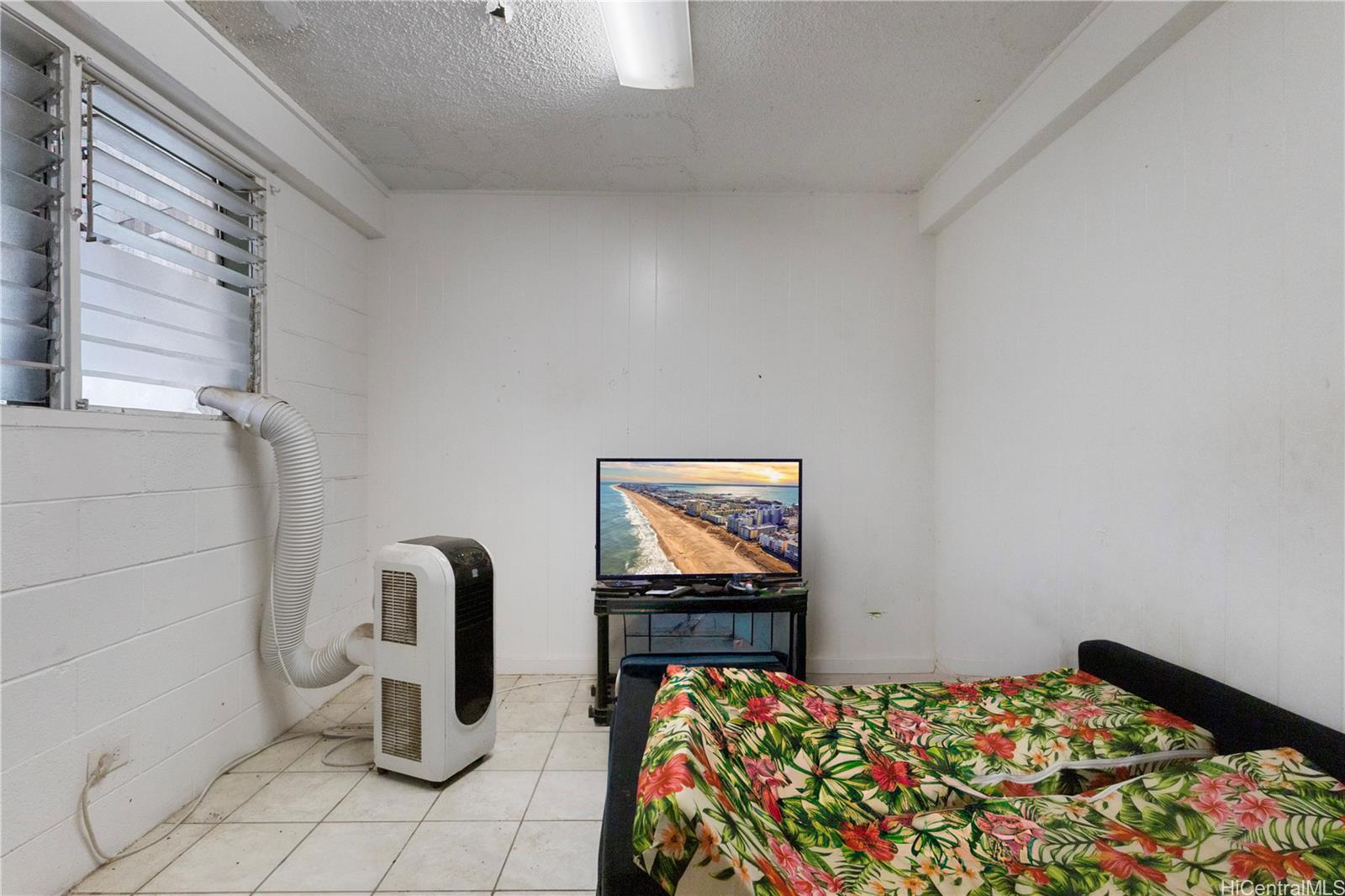 219 Kalihi Street Honolulu, HI 96819 - Photo 15 of 25 a bedroom with bed and glass door