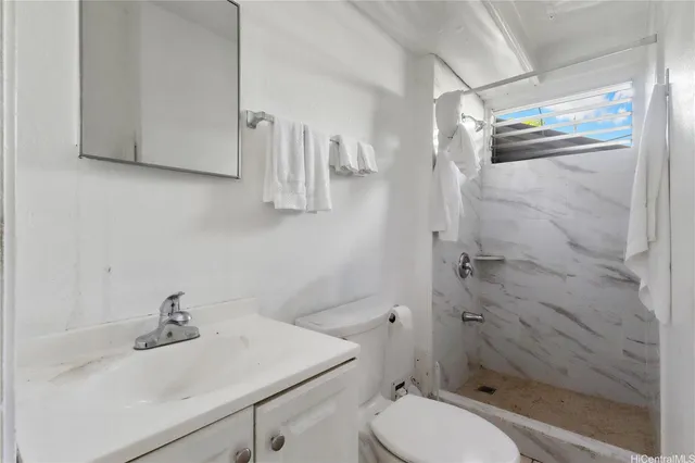 a bathroom with a sink a toilet and shower