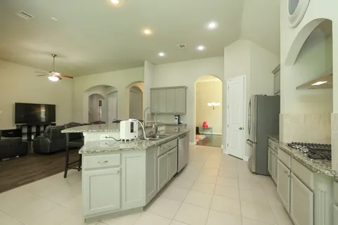 a large kitchen with a large counter top appliances and cabinets