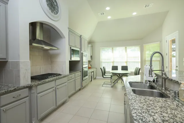 a kitchen with granite countertop a sink and a stove top oven
