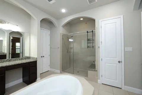 a spacious bathroom with a granite countertop sink mirror and shower