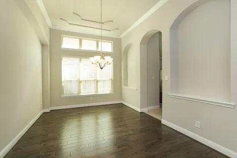 an empty room with wooden floor and a window