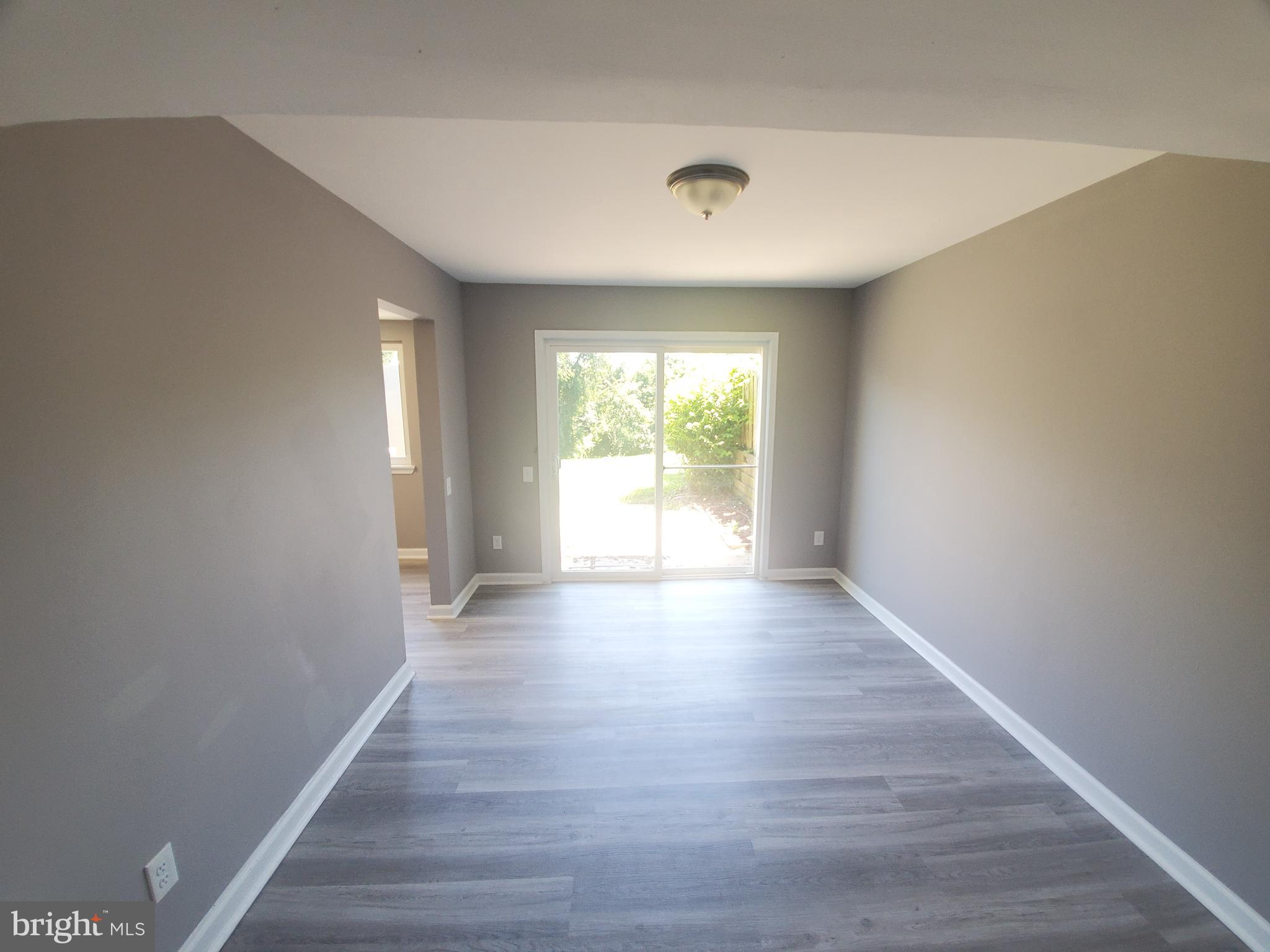 19349 Keymar Way Montgomery Village, MD 20886 - Photo 4 of 13 a view of an empty room with wooden floor and a window