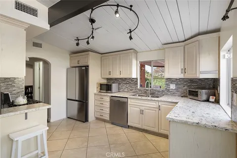a kitchen with stainless steel appliances granite countertop a stove a refrigerator and a sink