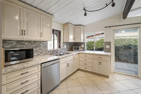 a kitchen with white cabinets appliances and a sink