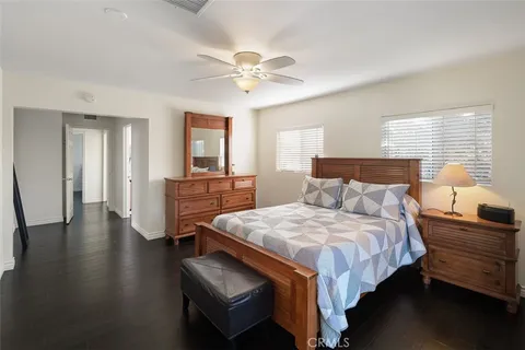 a bedroom with bed and wooden floor