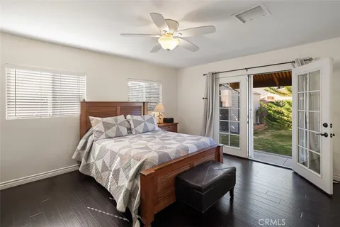 a bedroom with bed and wooden floor
