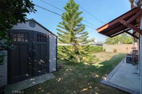 a backyard of a house with fountain table and chairs