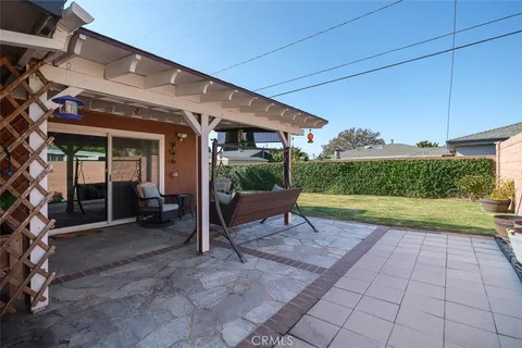 a view of a porch with a bench and potted plants