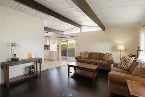 a living room with furniture wooden floor and a large window