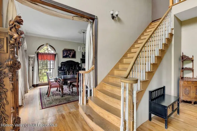 a view of a patio with couches table and chairs under an umbrella with wooden floor