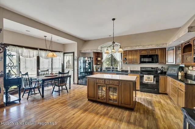 a view of a big house with a big yard and large trees