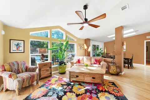 a dining room with furniture a large window and a kitchen view
