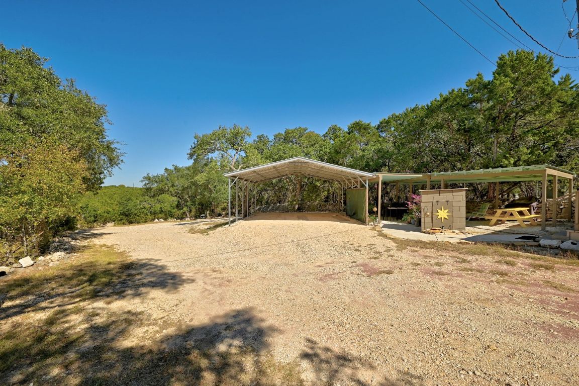 120 Cedar Bend Road Wimberley, TX 78676 - Photo 31 of 40 a backyard of a house with large trees and outdoor space