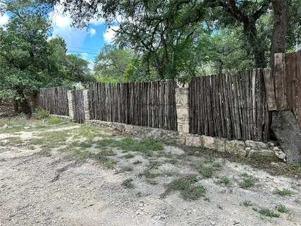 a view of a yard with plants and trees