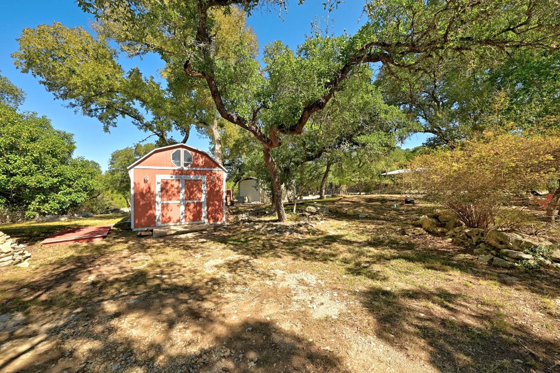 120 Cedar Bend Road Wimberley, TX 78676 - Photo 38 of 40 a view of a wooden house with a yard and large trees