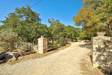 a backyard of a house with table and chairs and wooden fence