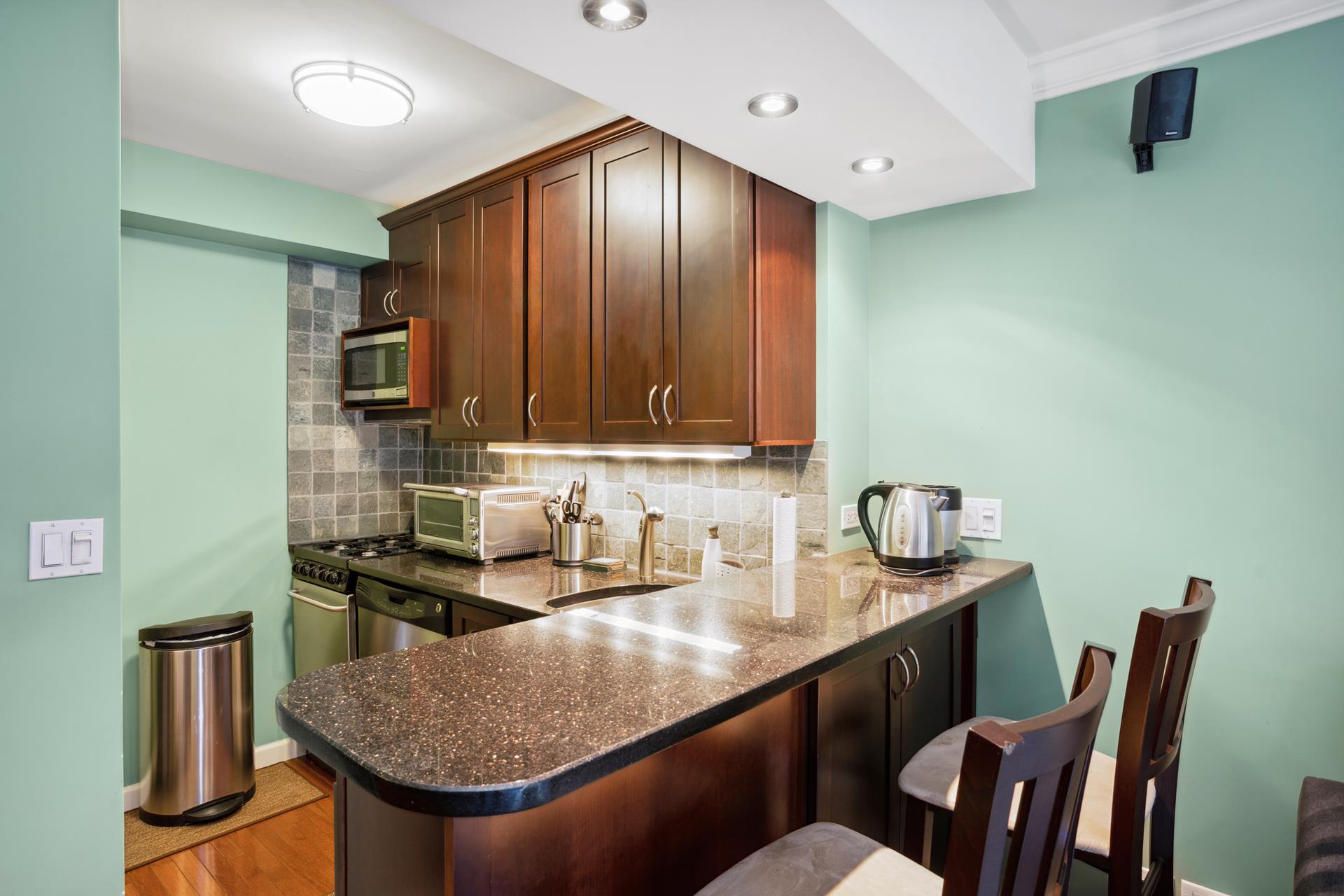 a kitchen with stainless steel appliances granite countertop a sink table and chairs