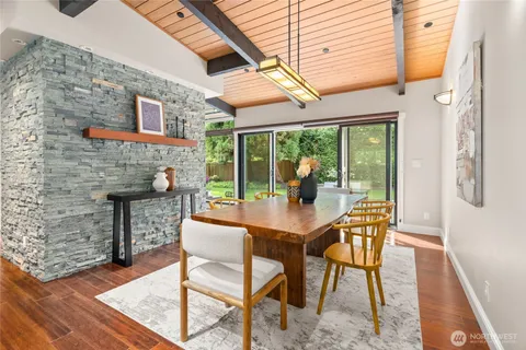 a dining room with furniture and a floor to ceiling window