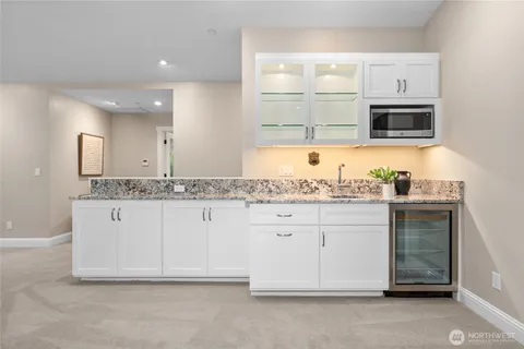a bathroom with granite countertop white cabinets and a sink