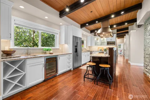 a kitchen with stainless steel appliances a table chairs refrigerator and sink
