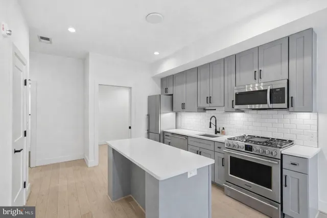 a kitchen with stainless steel appliances a stove microwave and cabinets