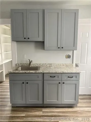 a kitchen with granite countertop white cabinets and sink