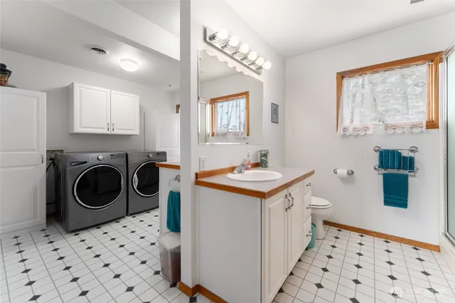 a utility room with sink dryer and washer