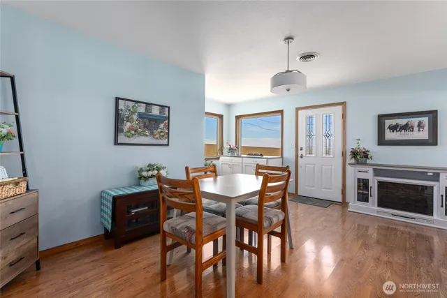 a kitchen with stainless steel appliances granite countertop a stove a sink and white cabinets with wooden floor