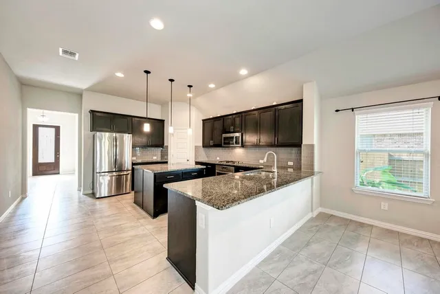 a kitchen with a stove sink and refrigerator