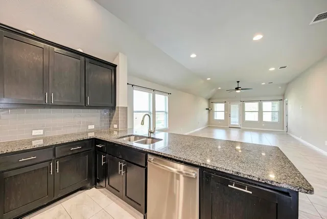 a kitchen with stainless steel appliances granite countertop a refrigerator and a sink