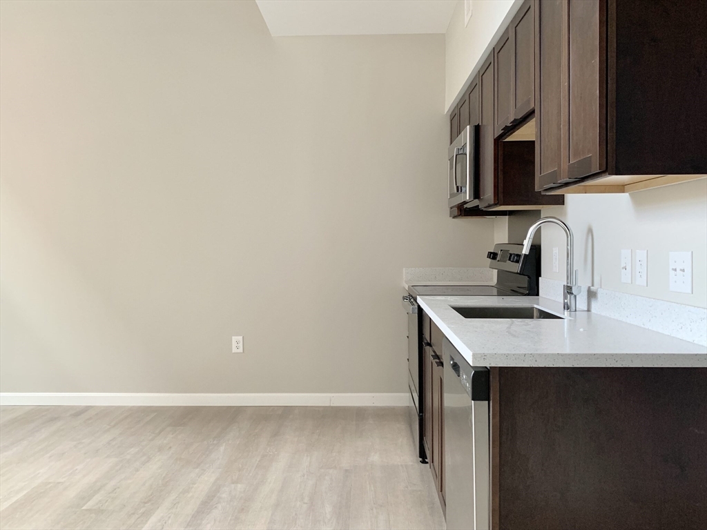 6 Chatham Street, Unit 104 Worcester, MA 01608 - Photo 2 of 6 a kitchen with a sink and a microwave