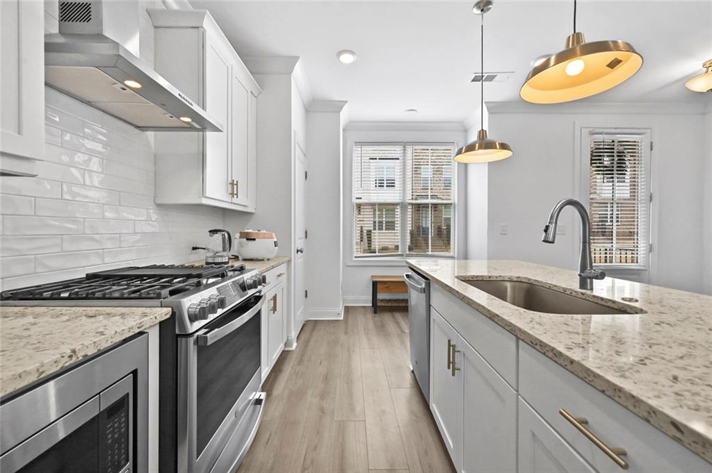 3217 Bartee Walk Suwanee, GA 30024 - Photo 14 of 36 a kitchen with a stove and a sink