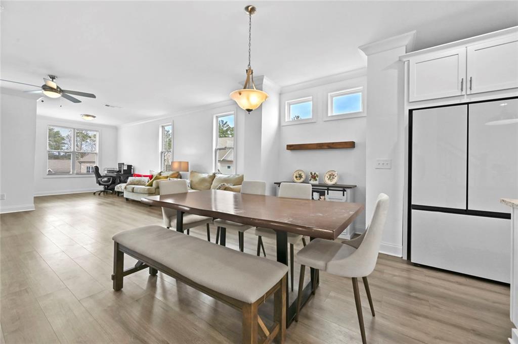 3217 Bartee Walk Suwanee, GA 30024 - Photo 15 of 36 a dining room with furniture a chandelier and wooden floor