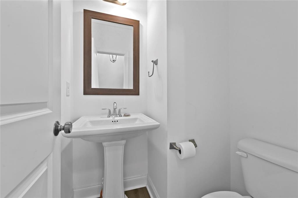 3217 Bartee Walk Suwanee, GA 30024 - Photo 23 of 36 a bathroom with a toilet a sink and mirror
