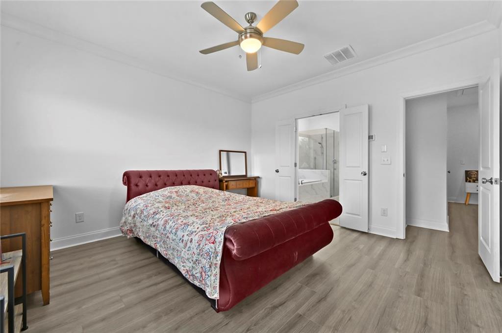 3217 Bartee Walk Suwanee, GA 30024 - Photo 26 of 36 a bedroom with a bed and a chandelier
