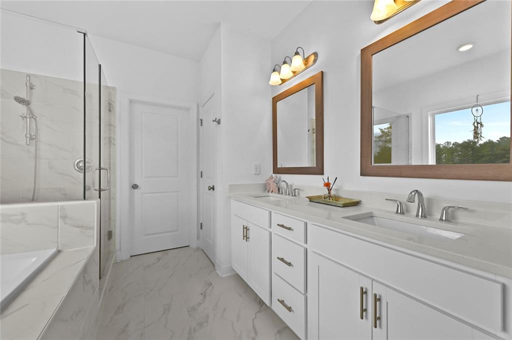 3217 Bartee Walk Suwanee, GA 30024 - Photo 28 of 36 a bathroom with a double vanity sink mirror and a bathtub
