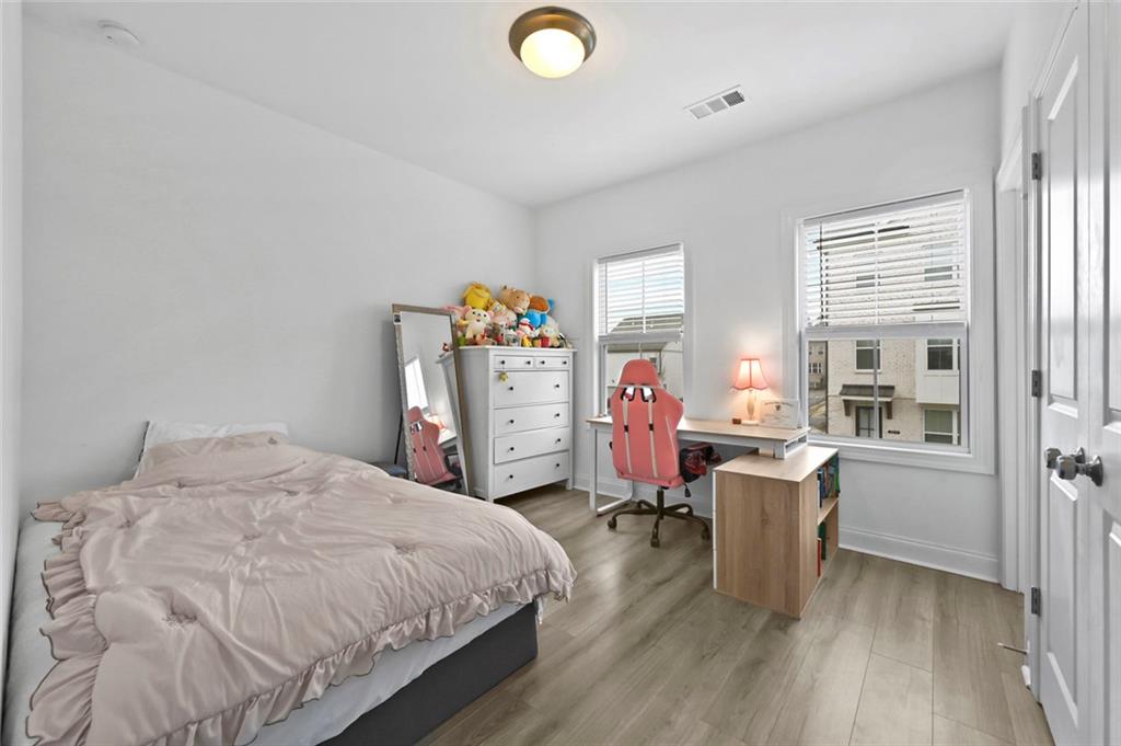 3217 Bartee Walk Suwanee, GA 30024 - Photo 29 of 36 a bedroom with a bed and a desk