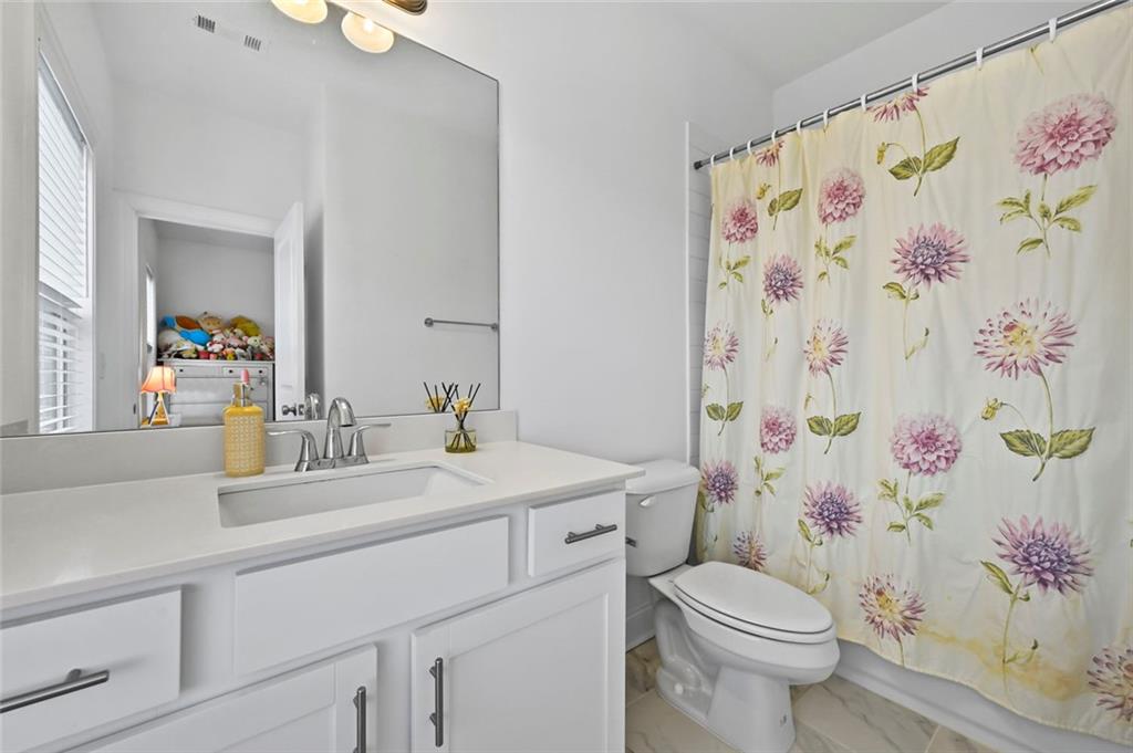 3217 Bartee Walk Suwanee, GA 30024 - Photo 31 of 36 a bathroom with a sink toilet and a mirror