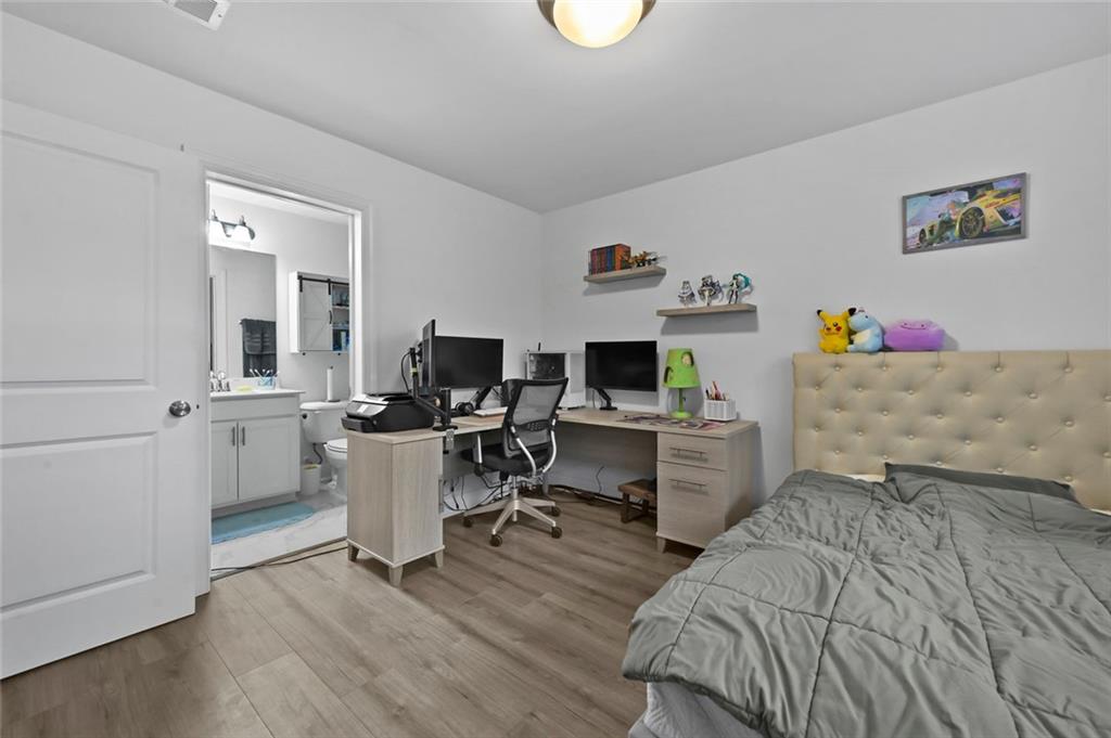 3217 Bartee Walk Suwanee, GA 30024 - Photo 34 of 36 a bedroom with a bed and a chair in it