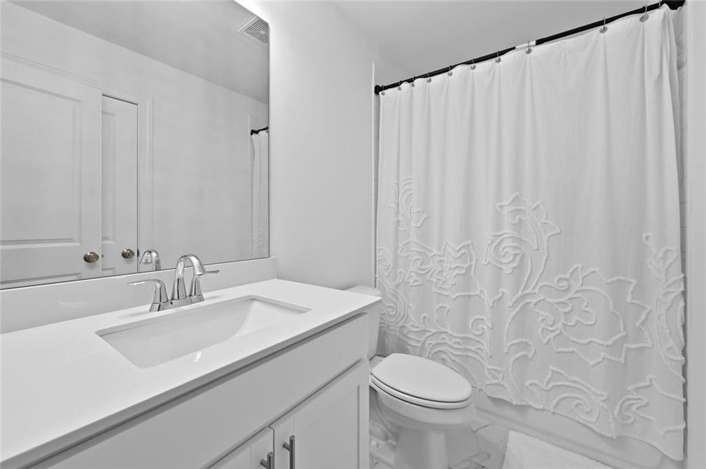 3217 Bartee Walk Suwanee, GA 30024 - Photo 35 of 36 a bathroom with a sink toilet and a mirror