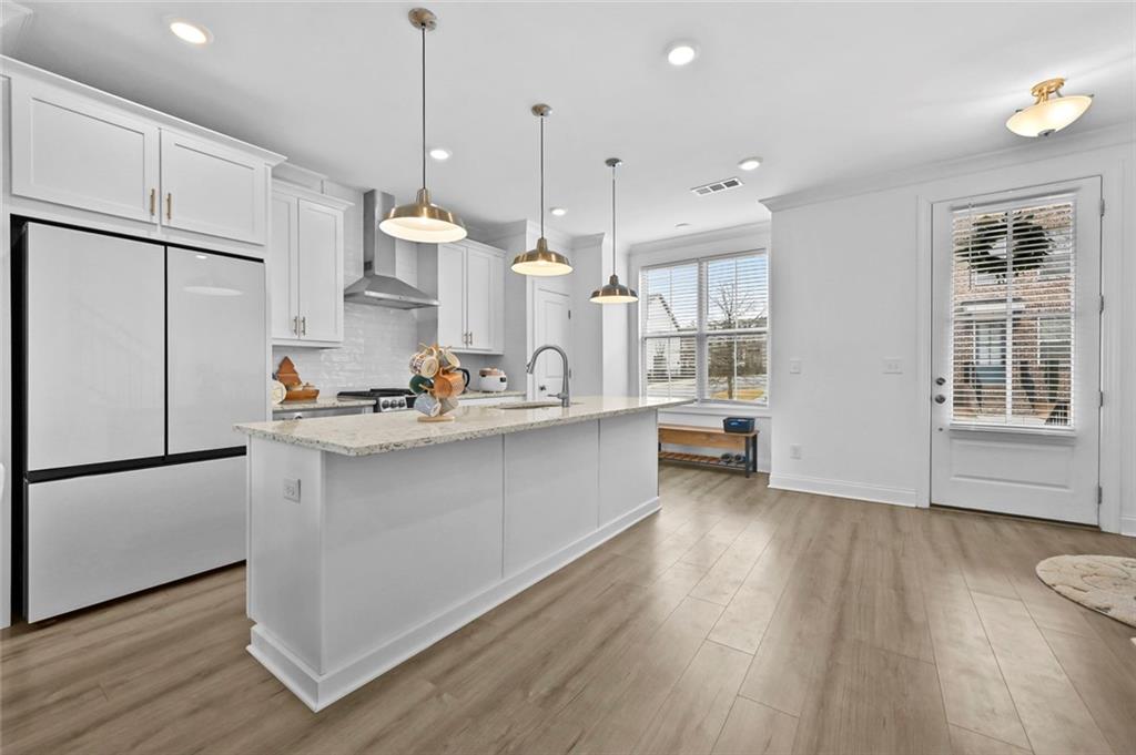 3217 Bartee Walk Suwanee, GA 30024 - Photo 10 of 36 a kitchen with stainless steel appliances granite countertop a refrigerator a sink dishwasher a refrigerator and white cabinets with wooden floor