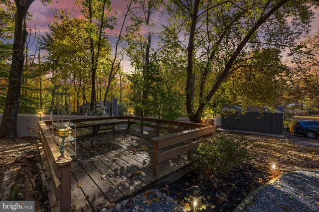 a view of a backyard with wooden fence and a bench