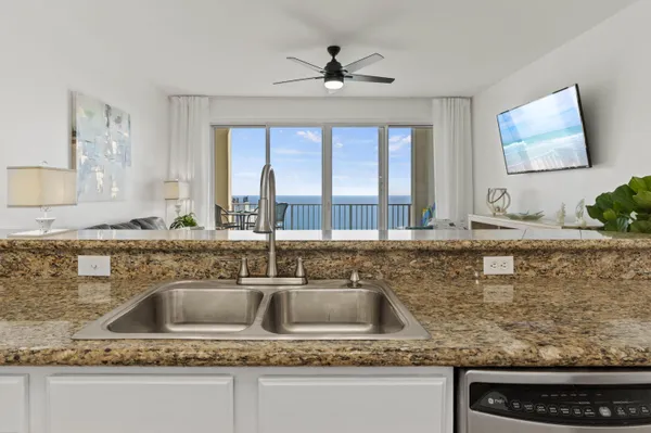a kitchen with kitchen island granite countertop a sink a counter top space and cabinets