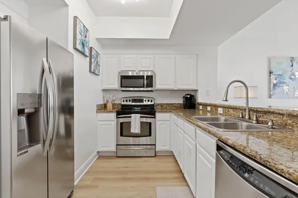 a kitchen with refrigerator a sink and stainless steel appliances