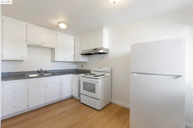 a kitchen with white cabinets and white appliances