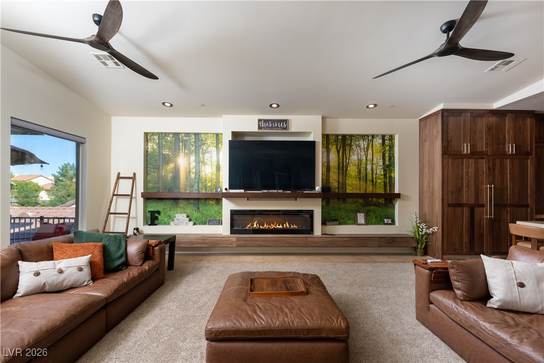 2817 High View Drive Henderson, NV 89014 - Photo 18 of 77 Carpeted living area with ceiling fan, a glass covered fireplace, and recessed lighting
