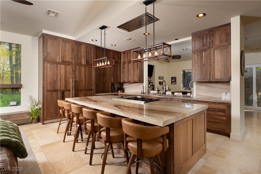 2817 High View Drive Henderson, NV 89014 - Photo 20 of 77 Kitchen featuring plenty of natural light, a kitchen island, brown cabinets, a kitchen bar, and recessed lighting