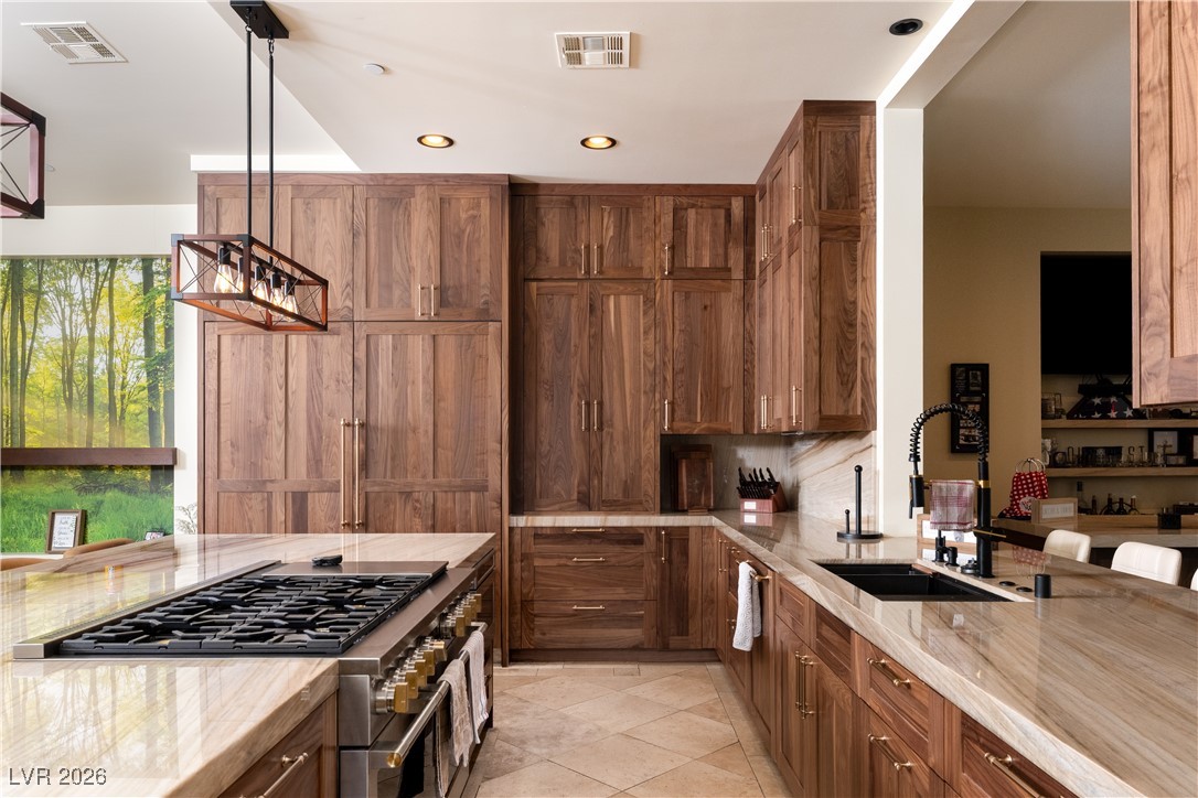 2817 High View Drive Henderson, NV 89014 - Photo 23 of 77 Kitchen featuring brown cabinets, pendant lighting, high end range, light stone counters, and recessed lighting
